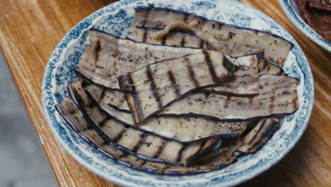 grilled eggplant in a plate on a wooden table