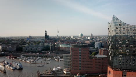 Hamburg-Harbour-Landungsbrücken-Skyline-Drone-Shot-during-golden-hour-in-the-sunset-with-Elbphilharmonie-in-the-foreground-Hamburger-Michel