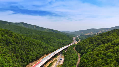 construction of a new freeway in the spectacular wooded mountains. building of the road above the old highways. aerial view
