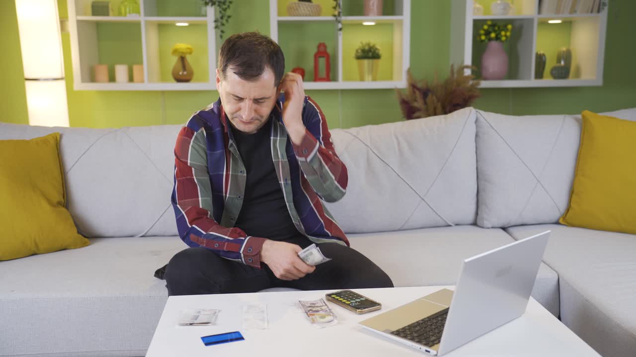después de pagar las cuentas, el hombre desesperado mira su dinero restante y piensa qué hacer.