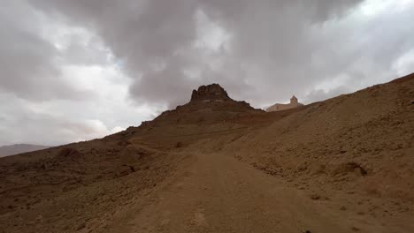 Road-to-Ksar-Guermessa-troglodyte-village-in-Tunisia-on-cloudy-day-with-mosque-in-background