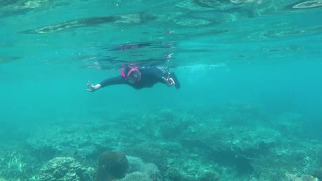 happy woman snorkeling and playing underwater with fish at karimun jawa