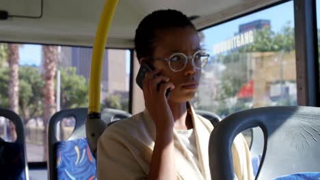 female commuter talking on mobile phone while travelling in bus 4k