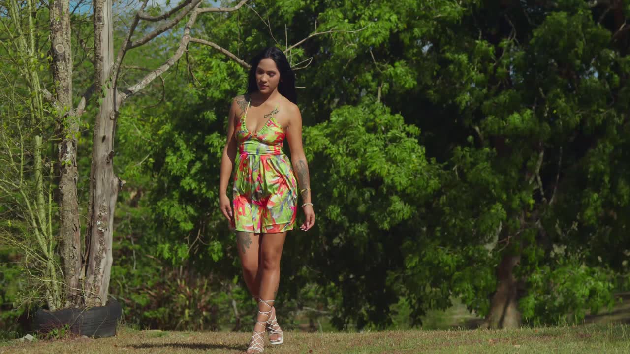 Sull'isola di Trinidad, una giovane ragazza latina in un vestito si gode la bellezza di un parco caraibico.