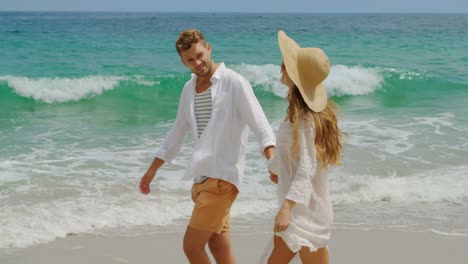 Side-view-of-Caucasian-couple-walking-hand-in-hand-on-the-beach-4k