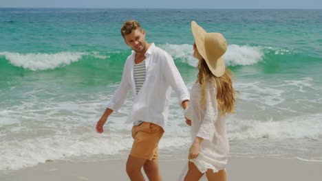 side view of caucasian couple walking hand in hand on the beach 4k