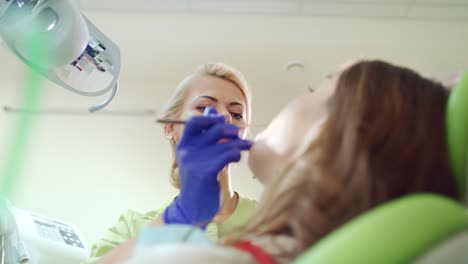 higienista dental chequea los dientes del paciente. profesional de estomatología trabajando