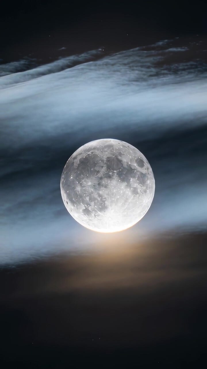 Nuvens em camadas flutuando da esquerda para a direita, velando e revelando o disco lunar para educação em astronomia.