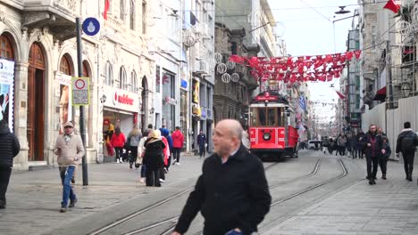 a streetcar drives through a crowded street in istanbul, turkey.
