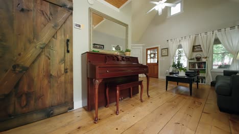 a push in shot of an old wooden piano in the living room of a farm house