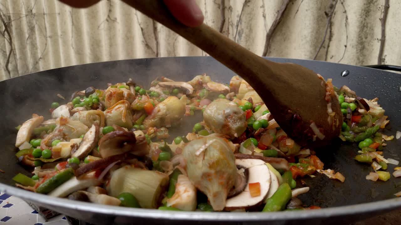 Evenly cooking food in a pan using wooden spoon