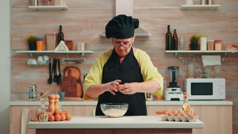 woman baker cracking eggs