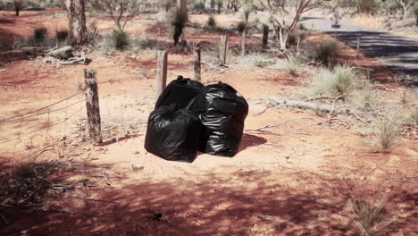 Primer-Plano-De-Bolsas-De-Basura-Llenas-En-La-Arena