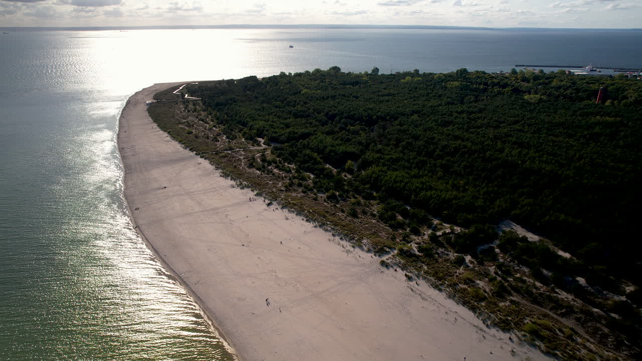 toma cinematográfica de drones de la playa de arena con el mar báltico y el reflejo del sol a la hora de la puesta del sol en hel, polonia