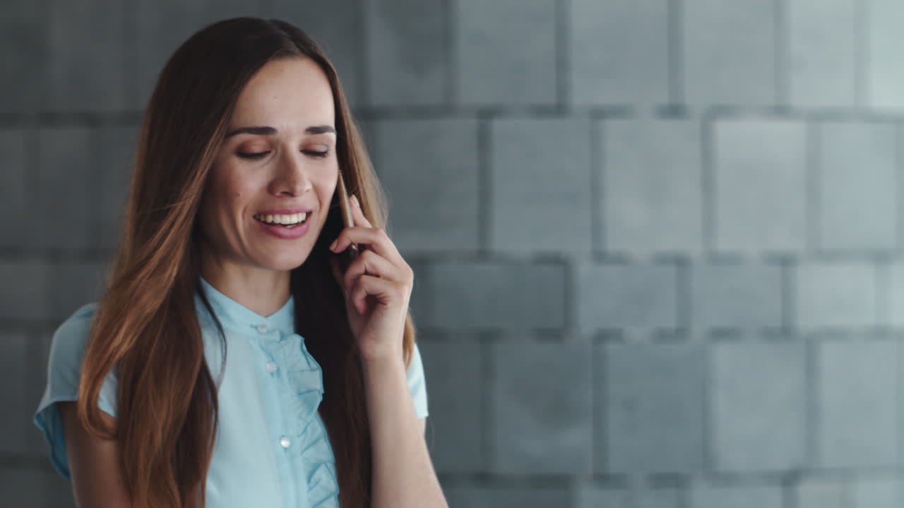 mujer de negocios sonriente teniendo una conversación en el teléfono inteligente al aire libre