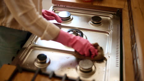 woman cleaning kitchen stove