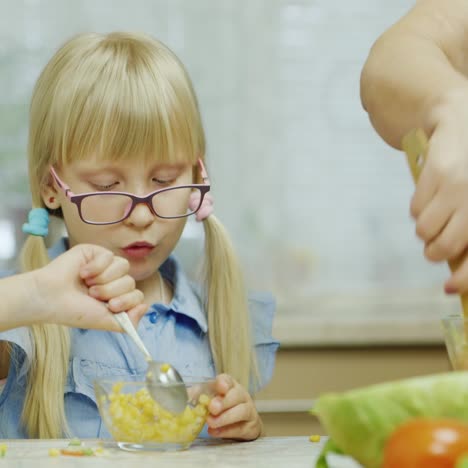 Una-Chica-Divertida-Come-Una-Ensalada-De-Un-Tazón-Grande-Junto-A-Su-Abuela