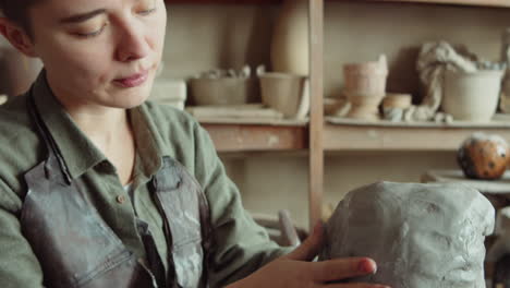 female sculptor working with clay in studio