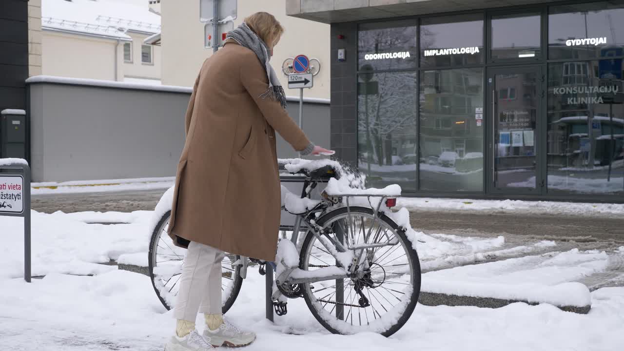 mujer joven dejó su bicicleta afuera durante el invierno