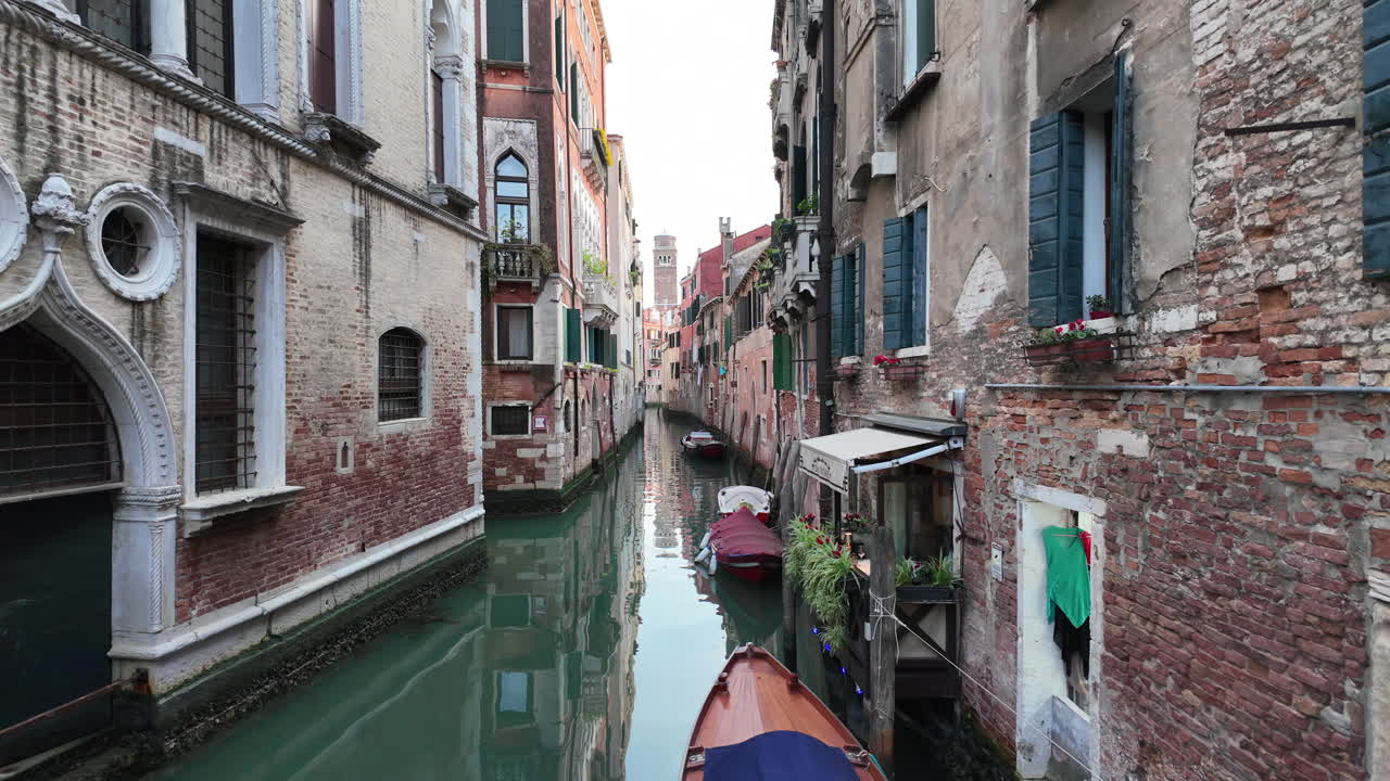 Boats docked on the side of a canal in Venice, Italy