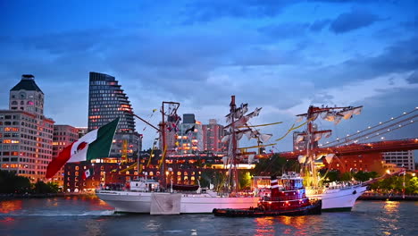 wrecked ship with broken mast and tug boat move to the berth. water accident in new york, usa at dusk time