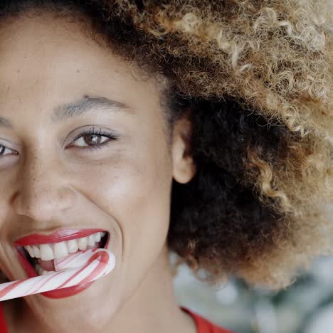 jovem mulher mordendo um bastão de doces festivo