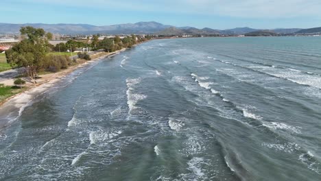 aerial footage of long waves on the beach on a sunny day