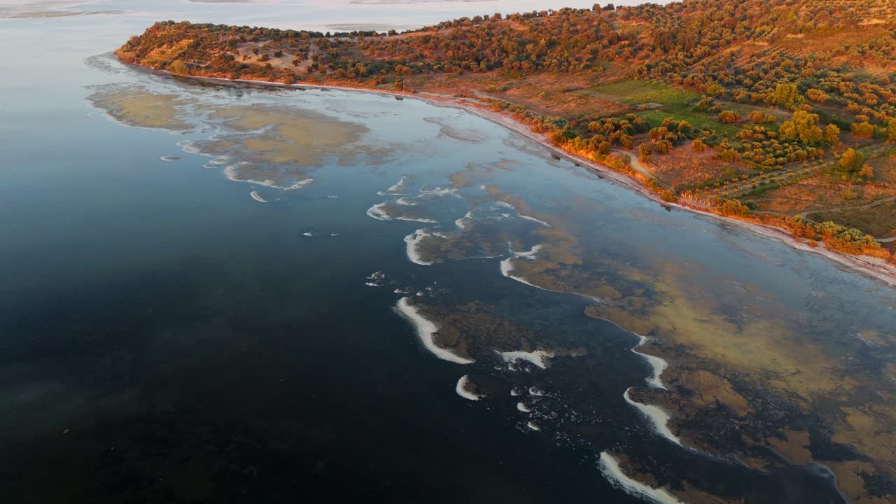 vista aérea del atardecer de una impresionante laguna albanesa con colores vibrantes y un paisaje sereno