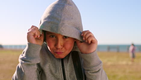 boy in a hoodie at the beach