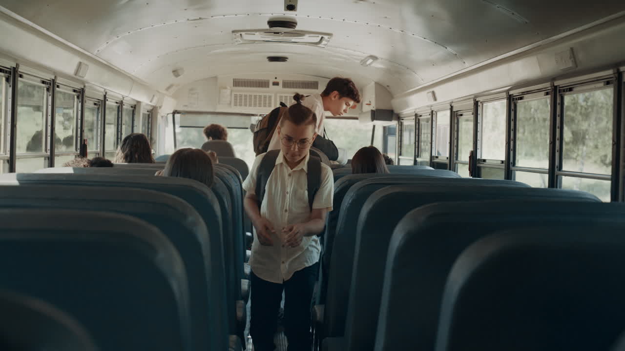 Schoolkinderen nemen plaats in de schoolbus. Tienerleerlingen stappen in het voertuig.