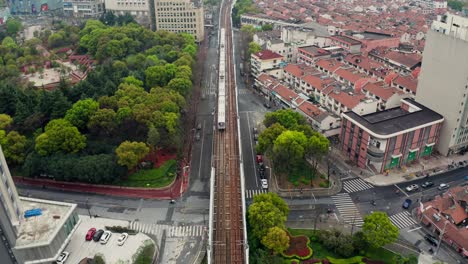 Toma-Aérea-De-4k-Del-Tren-Subterráneo-Entrando-En-Un-Túnel-Cubierto-De-Hierba-Verde