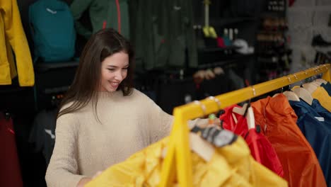 Una-Mujer-De-Compras-En-El-Centro-Comercial-Eligiendo-Ropa-Deportiva-En-Un-Estante