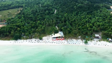 aerial reveal of idyllic white sand beach resort