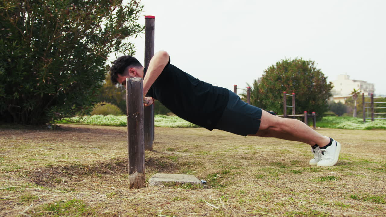 Man Does Push Ups Sport Exercise In The Park Using The Iron Bar
