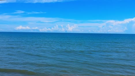 deep blue ocean and sky reveals waves and beach