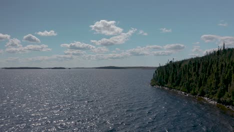 drone flying along the shores of a lake and forest on a beautiful summer day