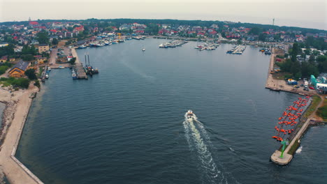 aerial view of motorboat sailing towards the marina in jastarnia, poland with moored yachts in the background