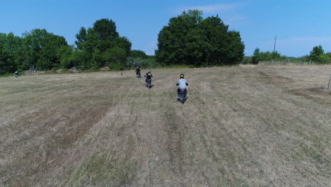 aerial drone view of kids riding dirt bikes in a field. location france