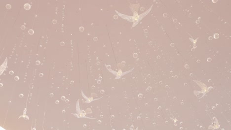 ethereal hanging birds with beads and bubbles in dreamy ambient glow