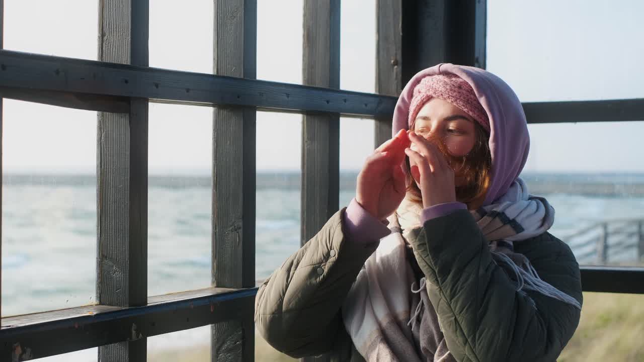 Woman in a winter coat by the sea