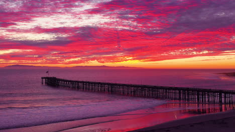 una asombrosa toma aérea de la puesta de sol sobre un largo muelle y el océano pacífico y las islas del canal en ventura sur de california 3