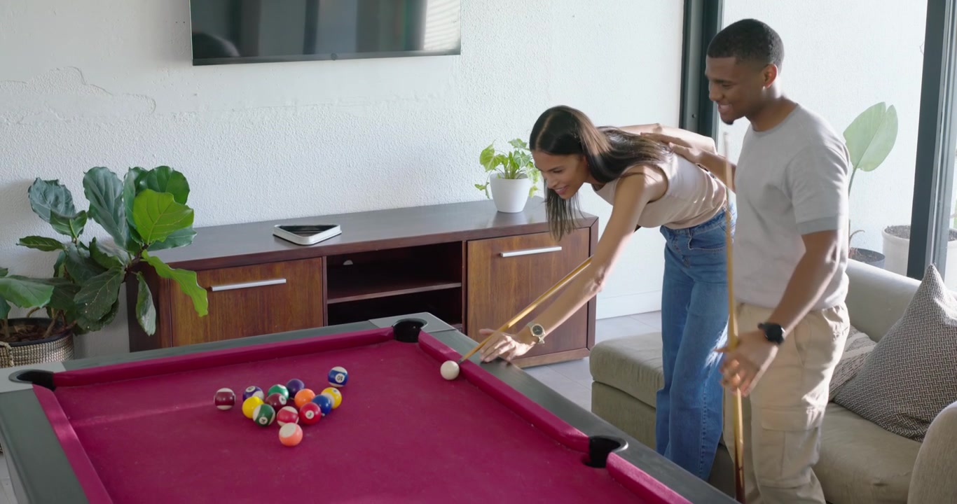 African American couple man taking light break woman playing, hitting cue on red table, copy space