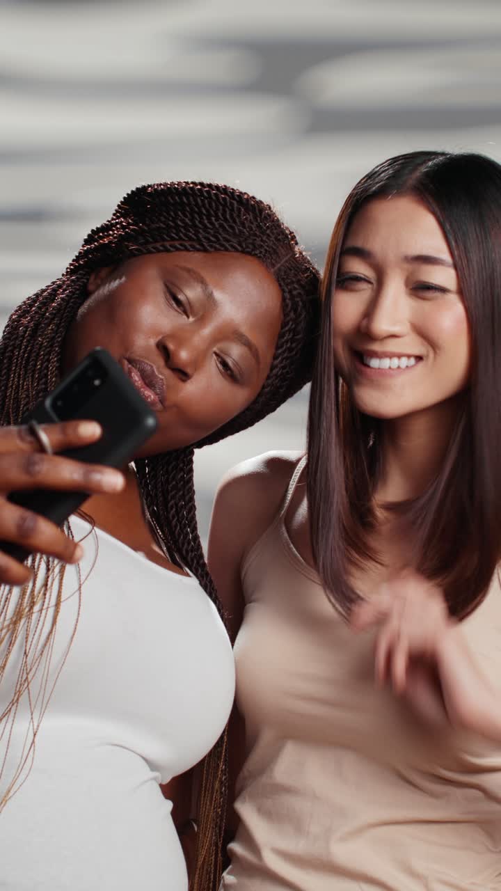 Vídeo vertical: duas modelos de skincare tirando fotos com smartphone