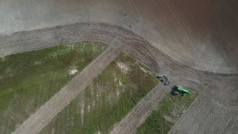 overhead aerial view of a tractor plowing a field for soybean cultivation