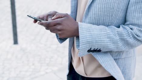 cropped view of woman texting on smartphone during stroll