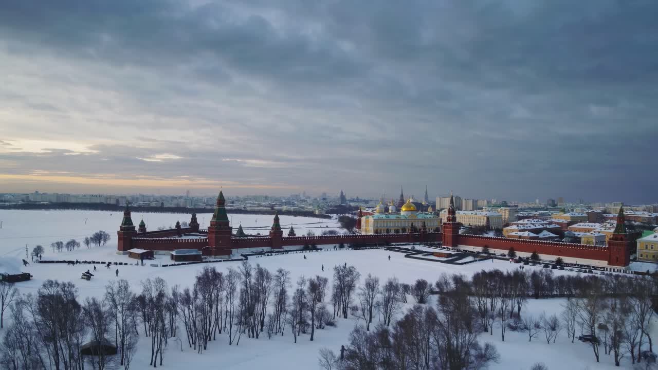 Luftvideo av et snødekt bybilde med historiske røde murbygninger og en skyet himmel