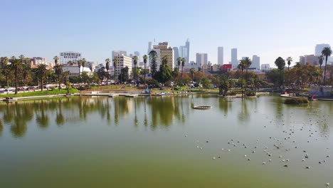 Antena-Del-Lago-Macarthur-Park,-Cerca-Del-Centro-De-Los-Angeles-California-Wishire-District-Con-El-Horizonte-De-La-Ciudad-Antecedentes