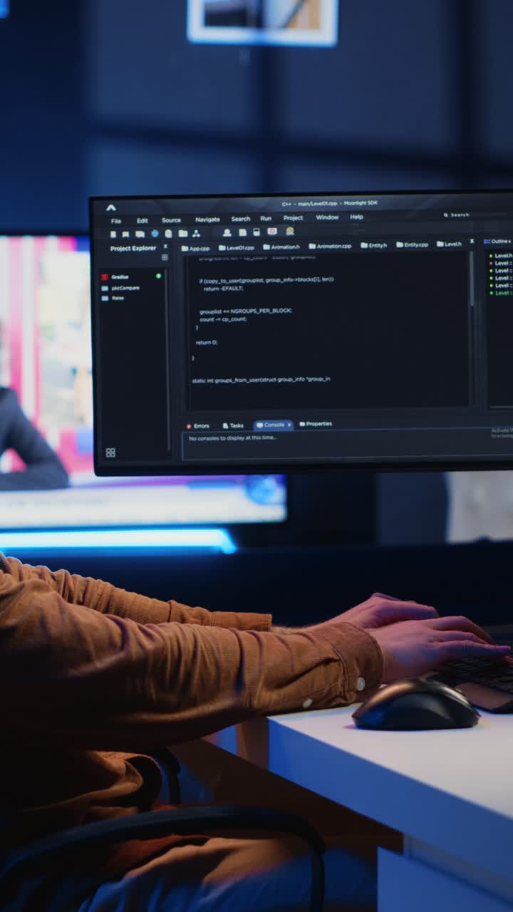 Fokuseret programmør, der koder på computerskærm om natten