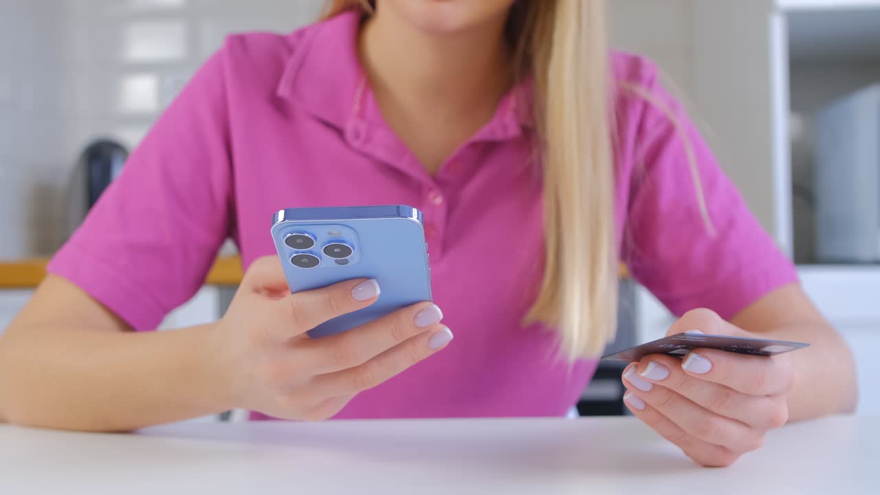 mujer comprando en línea con tarjeta de crédito y aplicación de teléfono móvil. mujer comprando en la tienda web con tarjeta bancaria y gadget de teléfono inteligente moderno en video. concepto de compras en casa filmado en 4k