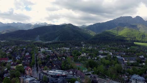 Sobrevuelo-De-Zakopane,-Polonia,-Un-Pueblo-Turístico-Con-Arquitectura-Goral-Tradicional-Cerca-De-Las-Montañas-Polacas-Tatra,-Tierras-De-Cultivo,-Bosques,-Pico-Giewont-Y-Gran-Salto-De-Esquí-Krokiew---4k-Panorámica-A-La-Derecha